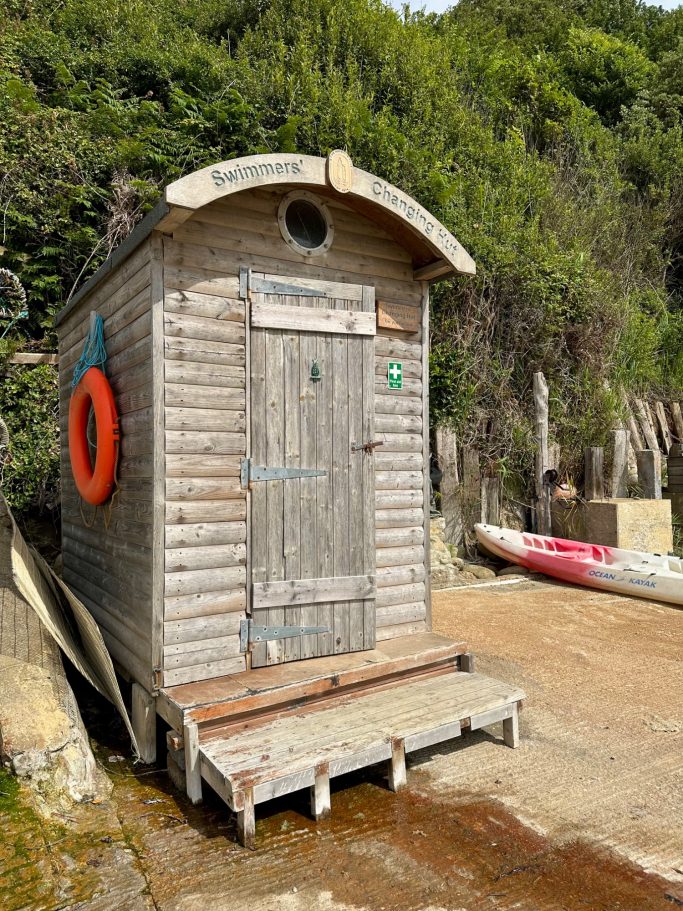 Beach changing hut at Castle Haven Beach, a perfect swimming spot just a 15-minute walk from 19 Evening Star chalet.