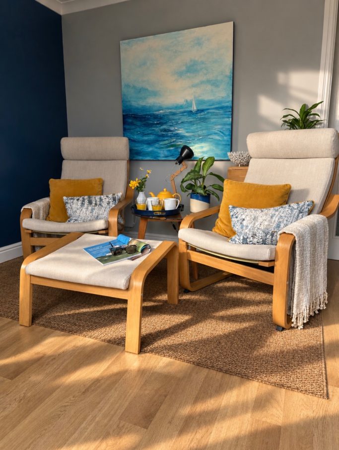 Bright and sunny lounge area at 19 Evening Star chalet on the Isle of Wight, featuring two comfortable armchairs and a coffee table with cup